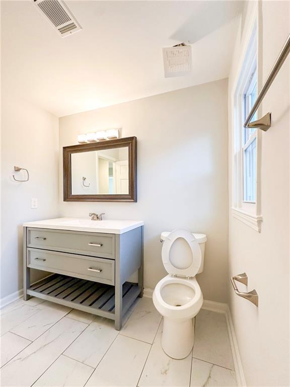 bathroom featuring vanity and toilet