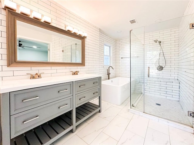 bathroom with plus walk in shower, tile walls, backsplash, vanity, and ceiling fan