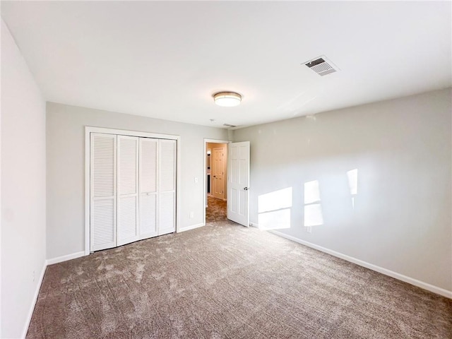 unfurnished bedroom featuring carpet and a closet