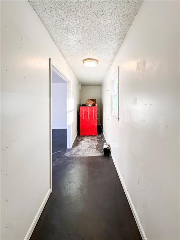 hall featuring a textured ceiling