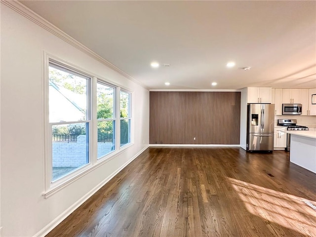 unfurnished living room with ornamental molding and dark hardwood / wood-style floors