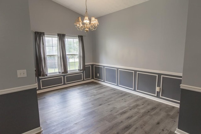 706 Hillmont Dr, Loganville, GA 30052 - empty room featuring a chandelier, lofted ceiling, wood finished floors, and a wainscoted wall