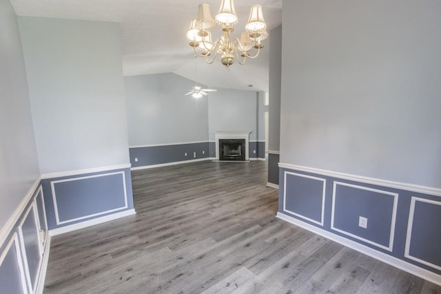 706 Hillmont Dr, Loganville, GA 30052 - unfurnished living room featuring a ceiling fan, a chandelier, lofted ceiling, wood finished floors, and a fireplace