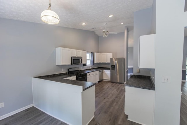 706 Hillmont Dr, Loganville, GA 30052 - kitchen with appliances with stainless steel finishes, dark countertops, a textured ceiling, white cabinets, and dark wood-style flooring