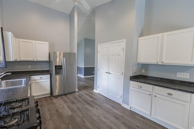 706 Hillmont Dr, Loganville, GA 30052 - kitchen with stainless steel fridge, stove, white cabinets, dark wood finished floors, and a ceiling fan
