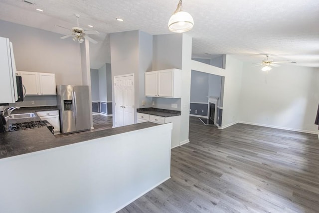 706 Hillmont Dr, Loganville, GA 30052 - kitchen with stainless steel fridge with ice dispenser, a ceiling fan, dark countertops, high vaulted ceiling, and a textured ceiling