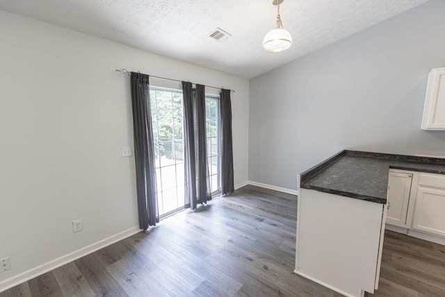 706 Hillmont Dr, Loganville, GA 30052 - unfurnished dining area featuring dark wood-type flooring and a textured ceiling