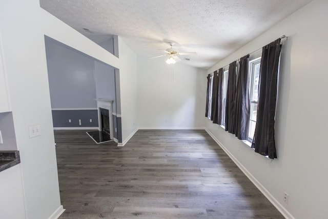 706 Hillmont Dr, Loganville, GA 30052 - empty room featuring a textured ceiling, a ceiling fan, wood finished floors, and a fireplace with raised hearth