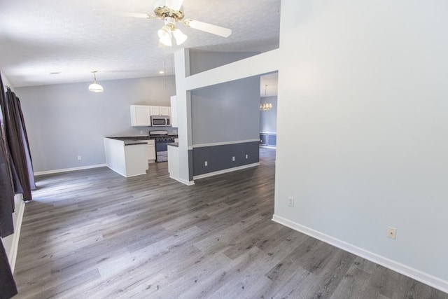 706 Hillmont Dr, Loganville, GA 30052 - unfurnished living room with lofted ceiling, wood finished floors, ceiling fan, a chandelier, and a textured ceiling