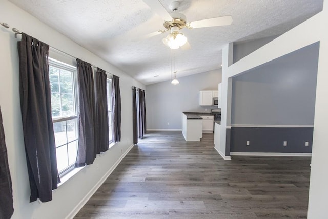 706 Hillmont Dr, Loganville, GA 30052 - unfurnished living room with a textured ceiling, lofted ceiling, dark wood-style floors, and a ceiling fan