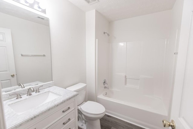 706 Hillmont Dr, Loganville, GA 30052 - bathroom featuring wood finished floors, vanity, washtub / shower combination, and a textured ceiling