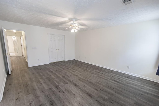 706 Hillmont Dr, Loganville, GA 30052 - unfurnished bedroom featuring dark wood-style flooring, a textured ceiling, a closet, and a ceiling fan