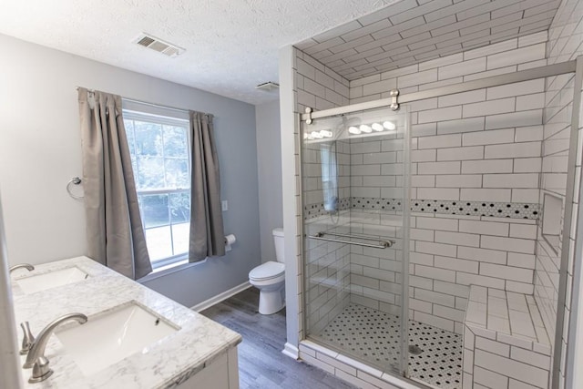 706 Hillmont Dr, Loganville, GA 30052 - full bathroom featuring a shower stall, wood finished floors, double vanity, and a textured ceiling