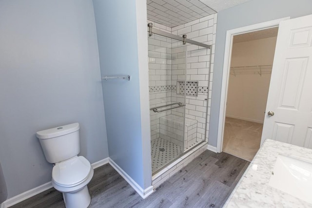 706 Hillmont Dr, Loganville, GA 30052 - full bath featuring a stall shower, wood finished floors, vanity, and a walk in closet