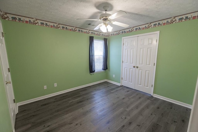 706 Hillmont Dr, Loganville, GA 30052 - unfurnished bedroom with a textured ceiling, dark wood-style flooring, a closet, and a ceiling fan