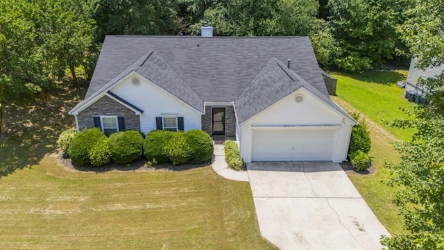 706 Hillmont Dr, Loganville, GA 30052 - view of front facade featuring a garage, a front lawn, concrete driveway, a chimney, and roof with shingles