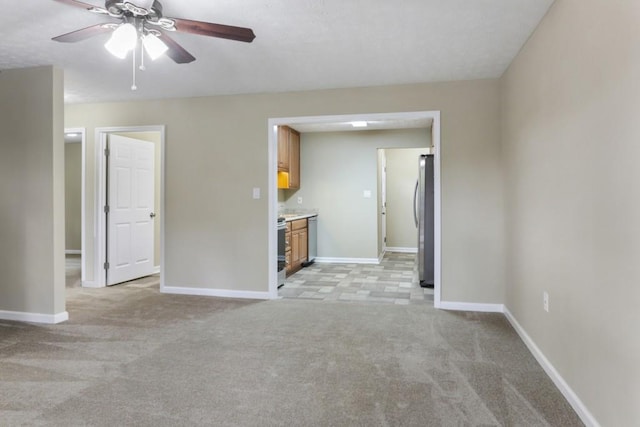 unfurnished living room featuring light carpet and ceiling fan