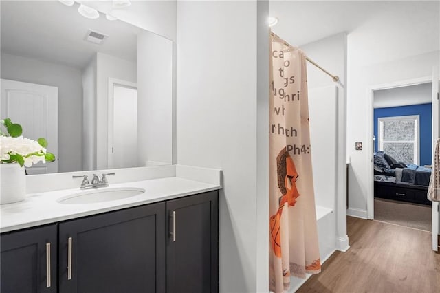 bathroom with wood-type flooring, vanity, and independent shower and bath