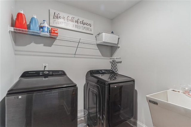 clothes washing area with washing machine and dryer and sink