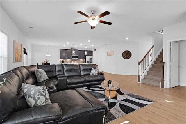 living room featuring light hardwood / wood-style flooring and ceiling fan