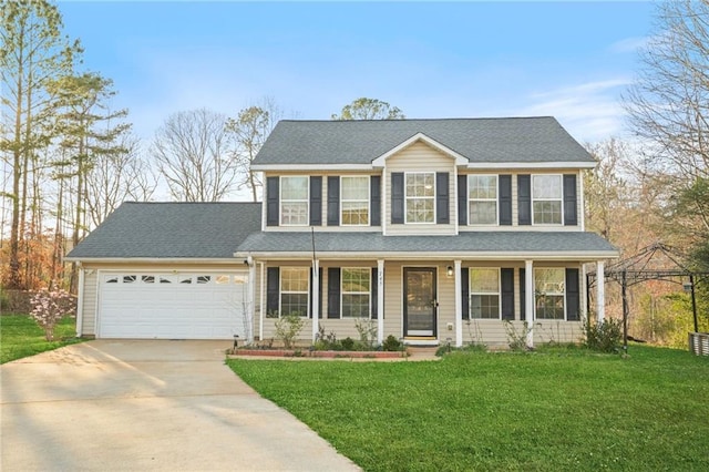 colonial-style house featuring a garage, a front lawn, covered porch, and driveway