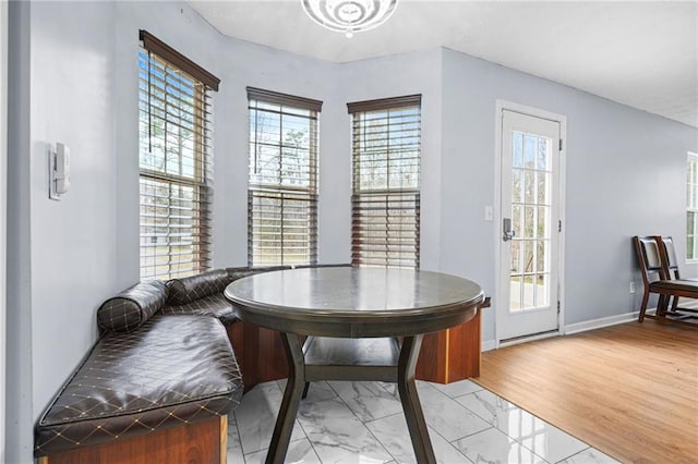 dining space with baseboards and light wood-type flooring