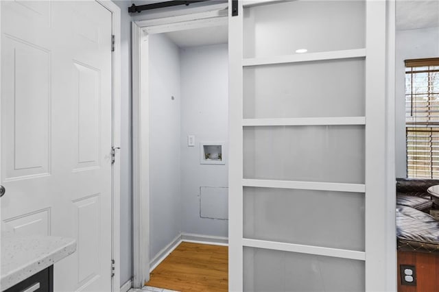 clothes washing area featuring hookup for a washing machine, wood finished floors, and laundry area