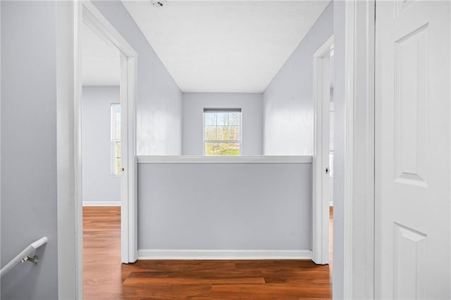 hallway with baseboards and wood finished floors