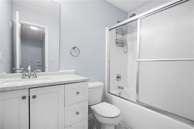 bathroom featuring combined bath / shower with glass door, toilet, and vanity