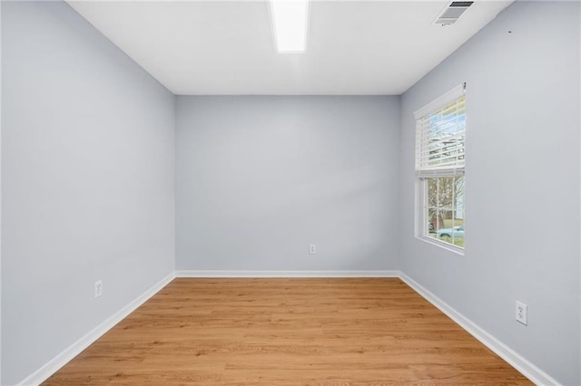 spare room with visible vents, light wood-style flooring, and baseboards