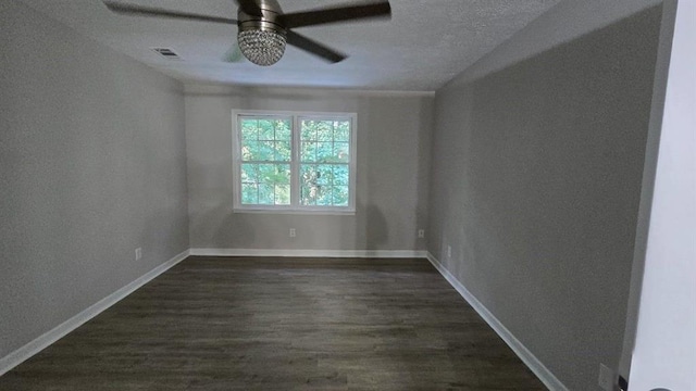 unfurnished room featuring dark wood-type flooring, visible vents, ceiling fan, and baseboards