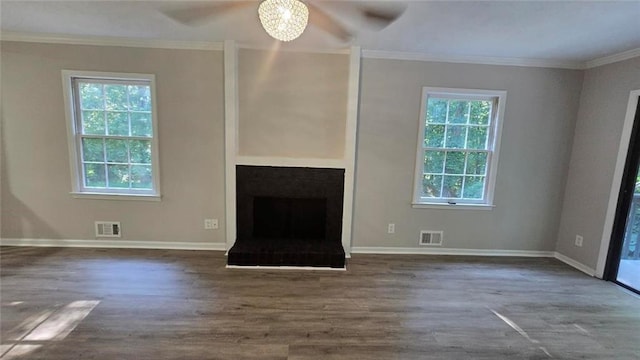 unfurnished living room with visible vents, crown molding, and wood finished floors