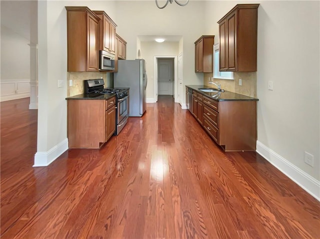 kitchen featuring stainless steel appliances, decorative backsplash, dark hardwood / wood-style flooring, and sink