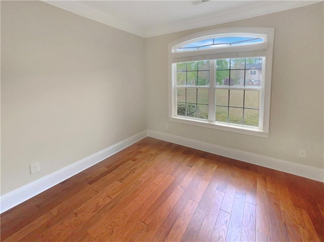 unfurnished room with ornamental molding and hardwood / wood-style floors