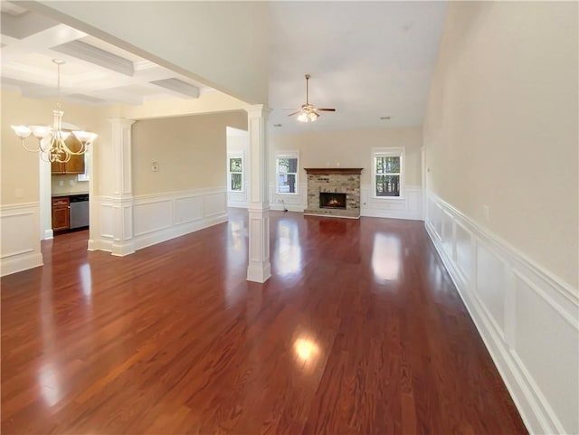 unfurnished living room with a fireplace, beamed ceiling, ceiling fan with notable chandelier, dark hardwood / wood-style floors, and coffered ceiling