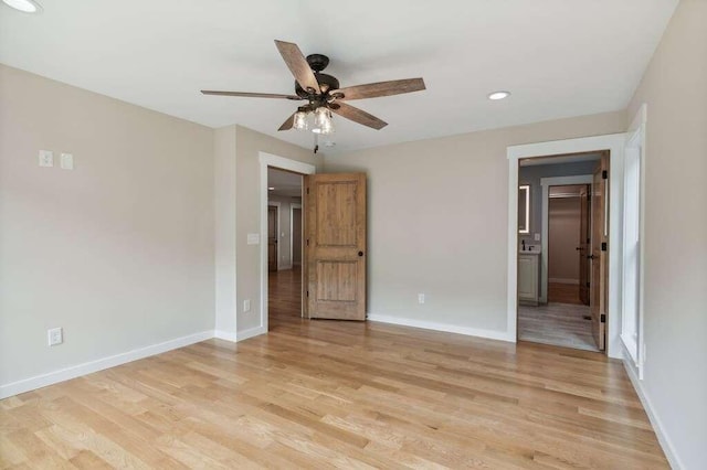 interior space with connected bathroom, light hardwood / wood-style flooring, and ceiling fan