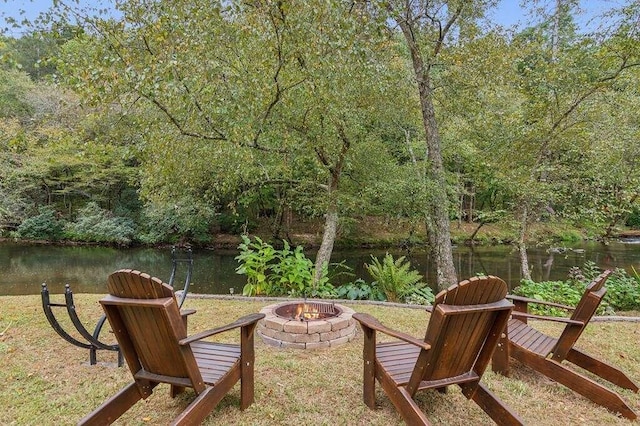 view of yard featuring a water view and an outdoor fire pit