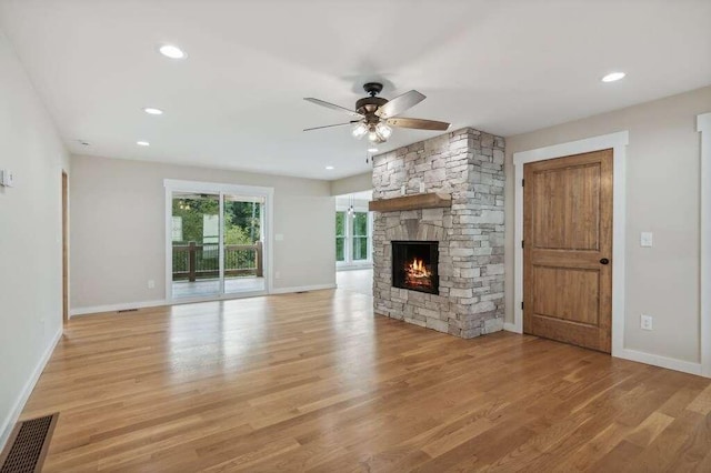 unfurnished living room with ceiling fan, a fireplace, and light hardwood / wood-style flooring