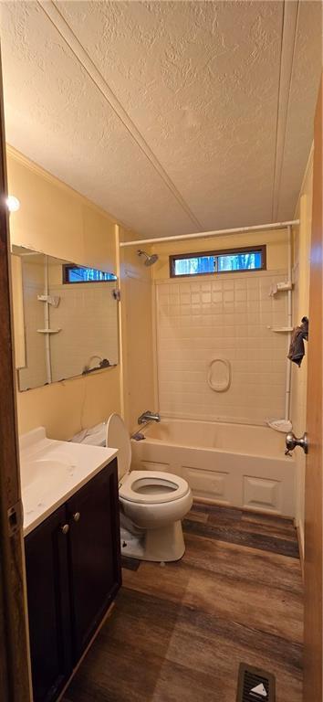 full bathroom with vanity, hardwood / wood-style floors, a textured ceiling, and toilet