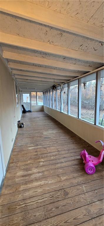 unfurnished sunroom featuring beam ceiling