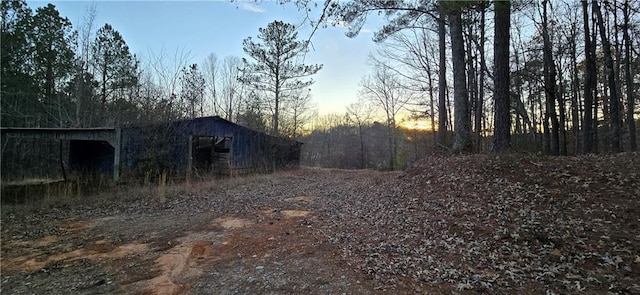 yard at dusk featuring an outdoor structure