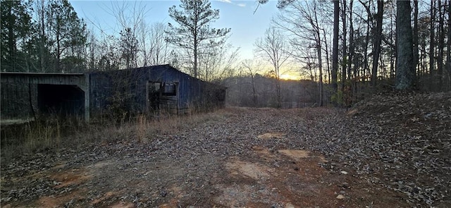 yard at dusk featuring an outdoor structure