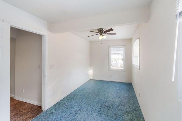 carpeted empty room with beamed ceiling and ceiling fan