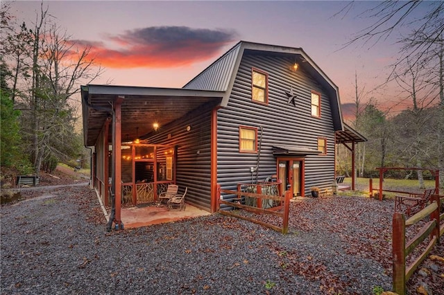 back house at dusk featuring a patio