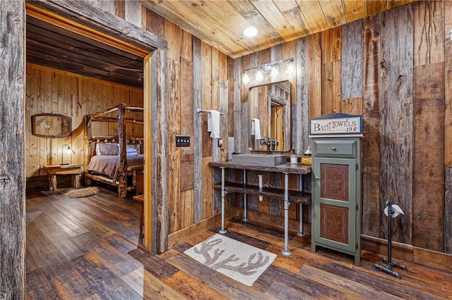 bathroom with wooden walls, sink, wooden ceiling, and hardwood / wood-style flooring