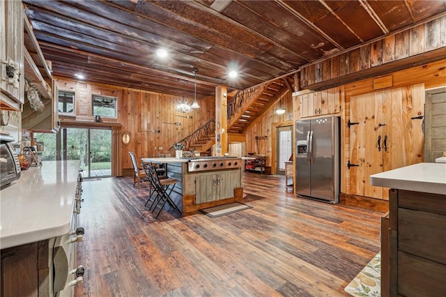 kitchen featuring dark hardwood / wood-style floors, wooden ceiling, stainless steel appliances, and wooden walls