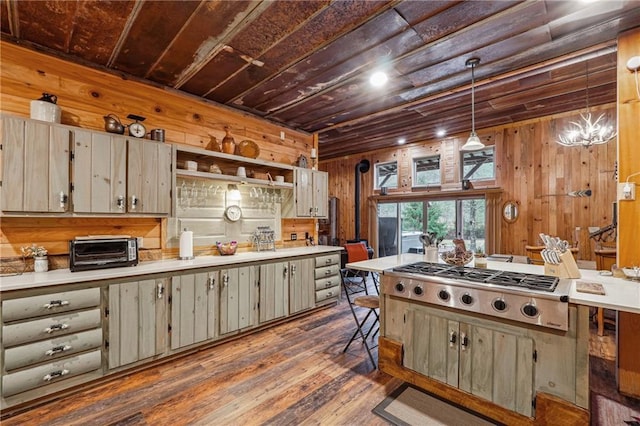 kitchen with wooden walls, dark wood-type flooring, pendant lighting, and an inviting chandelier