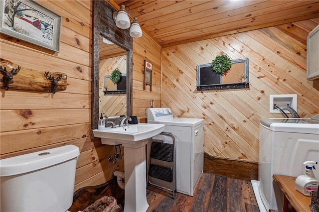 washroom with independent washer and dryer, dark hardwood / wood-style flooring, wooden ceiling, and wooden walls