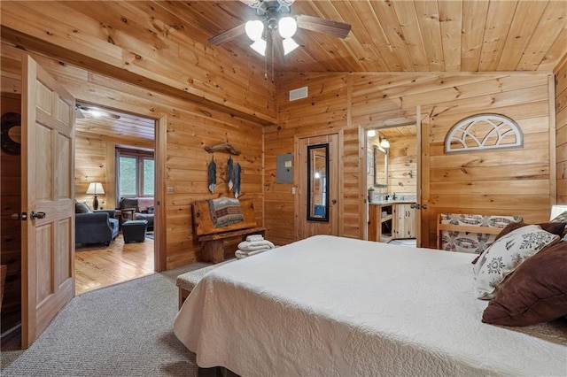 bedroom with wood ceiling, vaulted ceiling, ceiling fan, wooden walls, and hardwood / wood-style floors