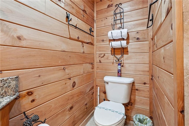 bathroom with wooden walls and toilet